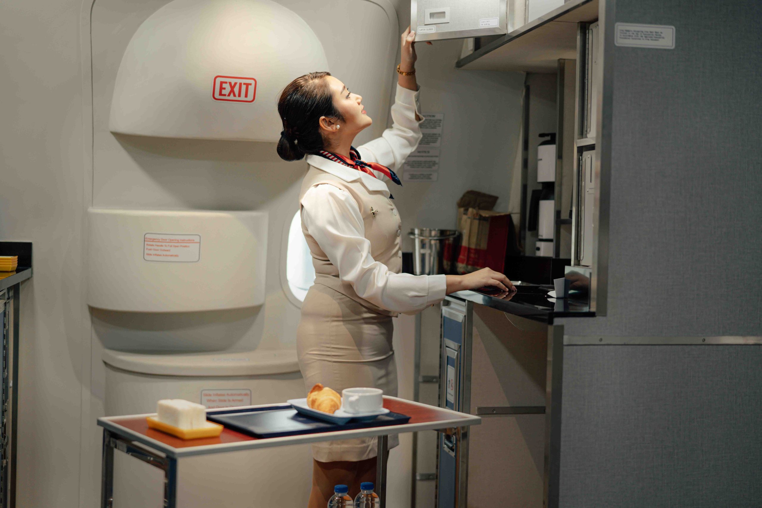 Cabin crew or air hostess working in airplane. Airline transportation and tourism concept.